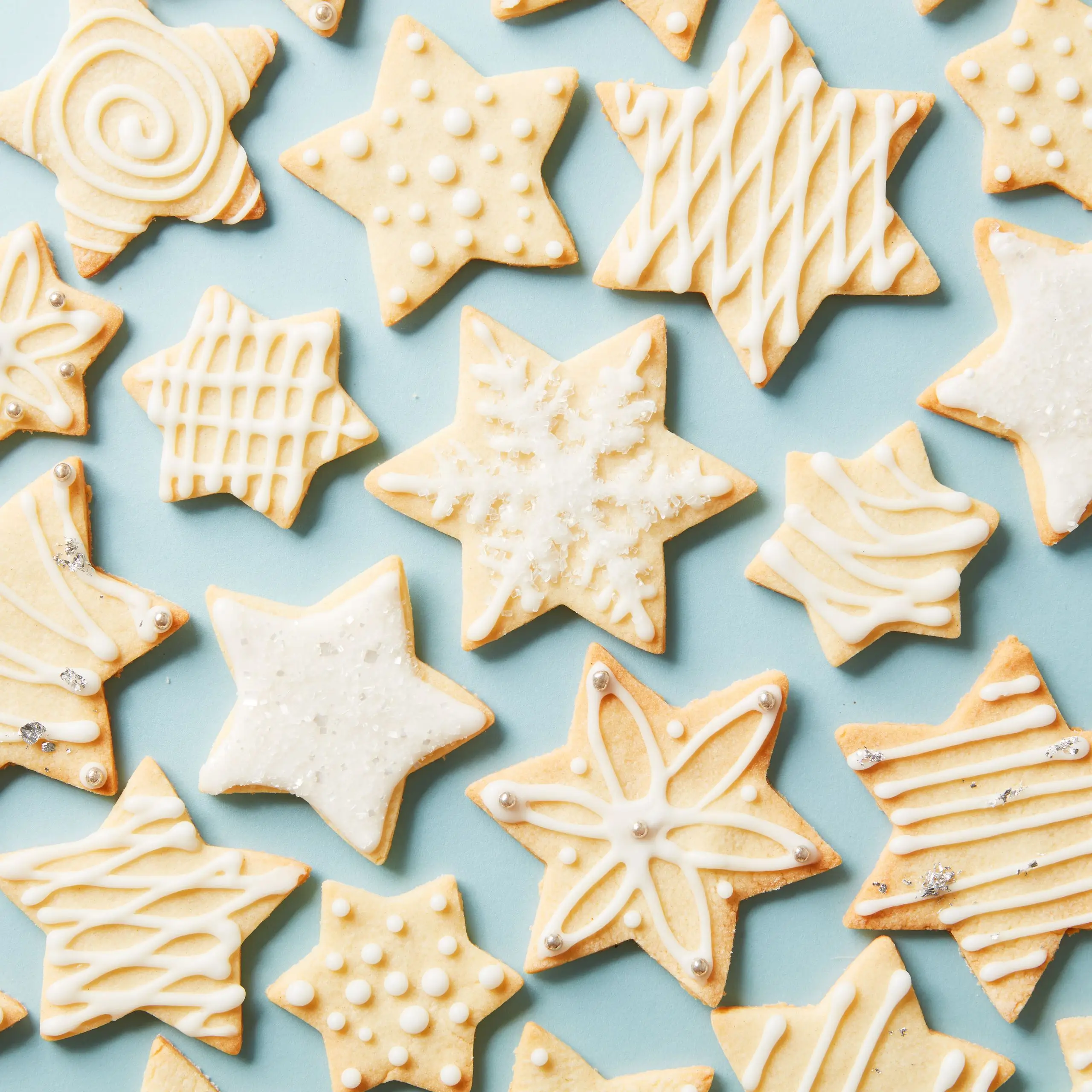 An assortment of decorated sugar cookies in star and snowflake shapes.