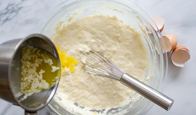 Pouring the butter into the sourdough pancake batter.' title='The Best Sourdough Pancakes