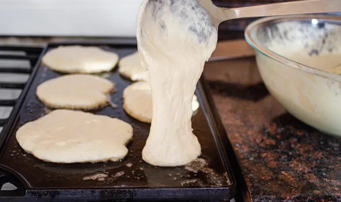 Ladling the sourdough pancake batter onto a hot griddle.' title='The Best Sourdough Pancakes