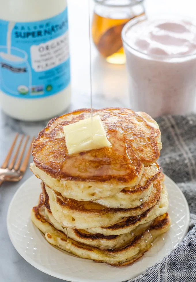 Drizzling maple syrup onto a stack of sourdough pancakes.' title='The Best Sourdough Pancakes
