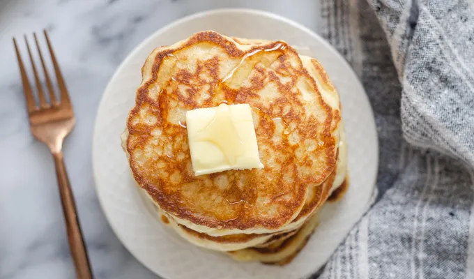 A stack of sourdough pancakes with a pat of butter and drizzle of maple syrup on top.' title='The Best Sourdough Pancakes