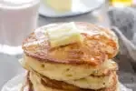 A stack of sourdough pancakes with a pat of butter and maple syrup dripping off the sides.' title='The Best Sourdough Pancakes