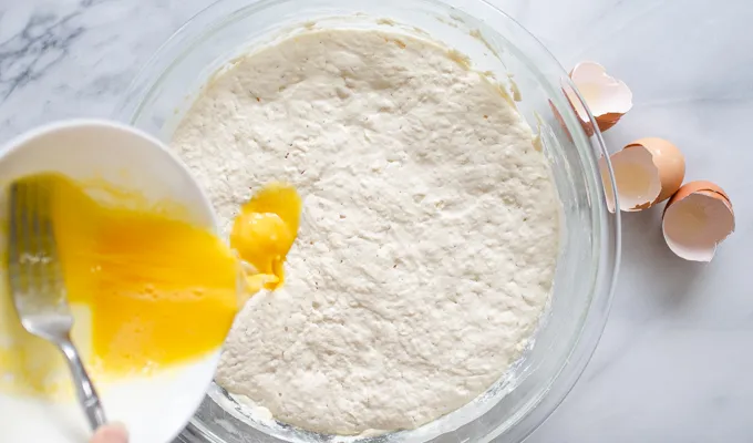 Pouring the eggs into the fermented batter.' title='The Best Sourdough Pancakes