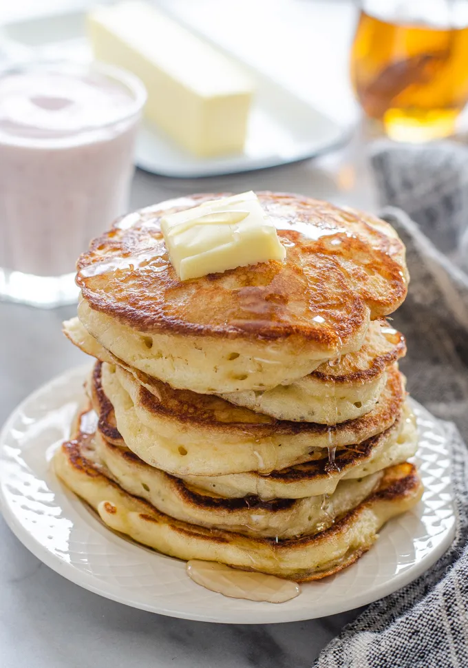 A stack of sourdough pancakes with a pat of butter and maple syrup dripping off the sides.' title='The Best Sourdough Pancakes