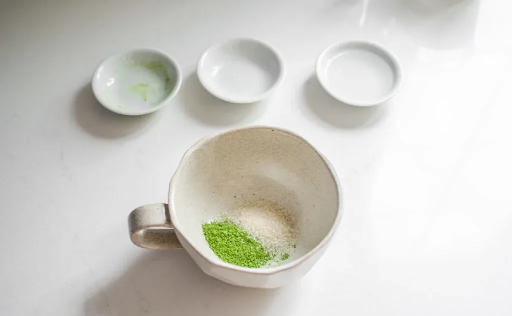 Matcha and sugar in a stoneware mug on a white countertop.' title='Starbucks Hot Matcha Green Tea Latte Recipe