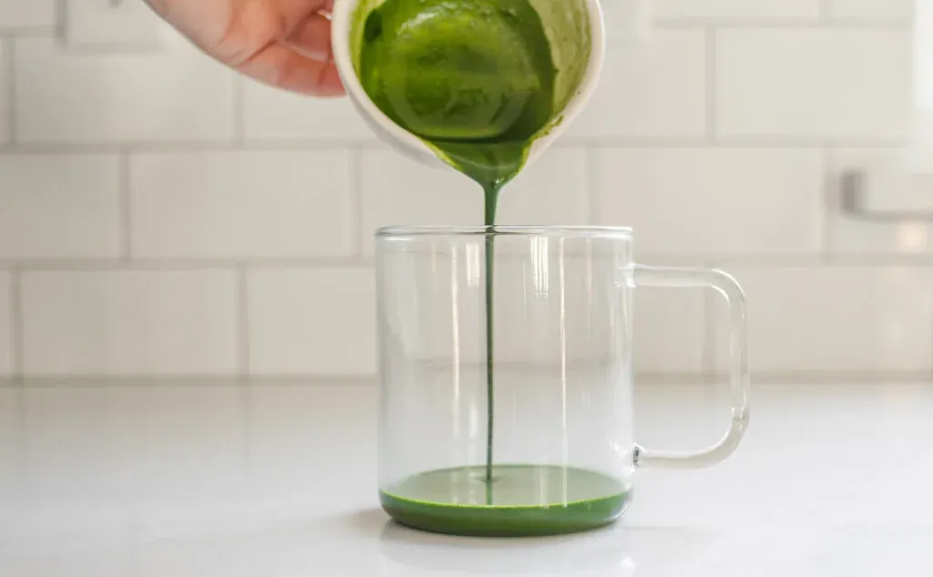 Pouring the whisked matcha and sugar mixture into a separate mug.' title='Starbucks Hot Matcha Green Tea Latte Recipe