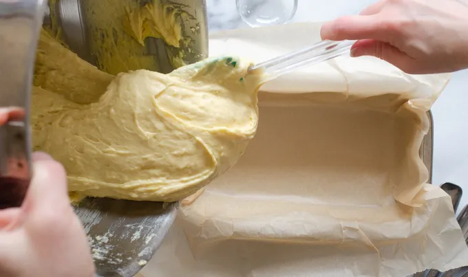 Scraping the batter into the parchment lined pan.' title='Sour Cream Pound Cake Loaf