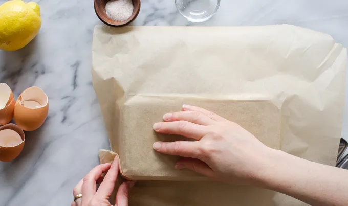 Folding parchment paper around the outside of a pan to make it fit better.' title='Sour Cream Pound Cake Loaf