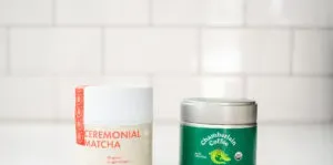 A tin of Rishi matcha next to a tin of Chamberlain matcha on a white countertop with a subway tile backsplash. ' title='BEST Organic Matcha Powder Review