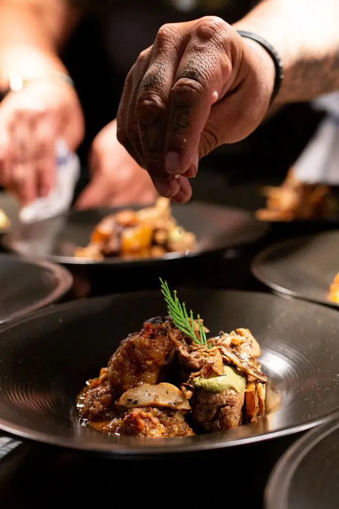 Owamni plating a dish