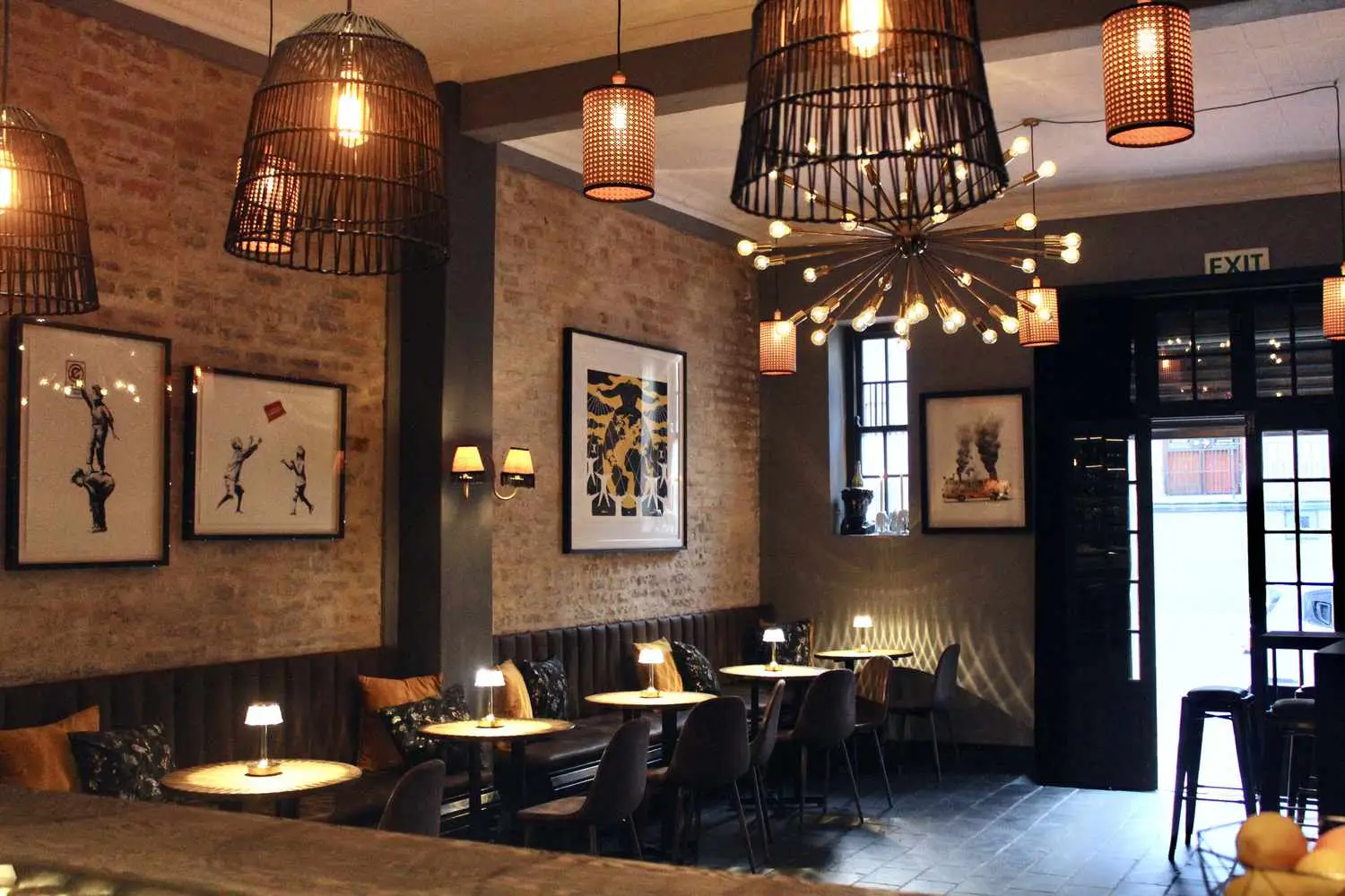 Interior of Talking to Strangers with banquette seating, brick walls, and moody lighting