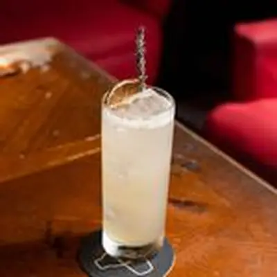 Lavender Mule in collins glass on coaster with lavender sprig and dehydrated orange wheel