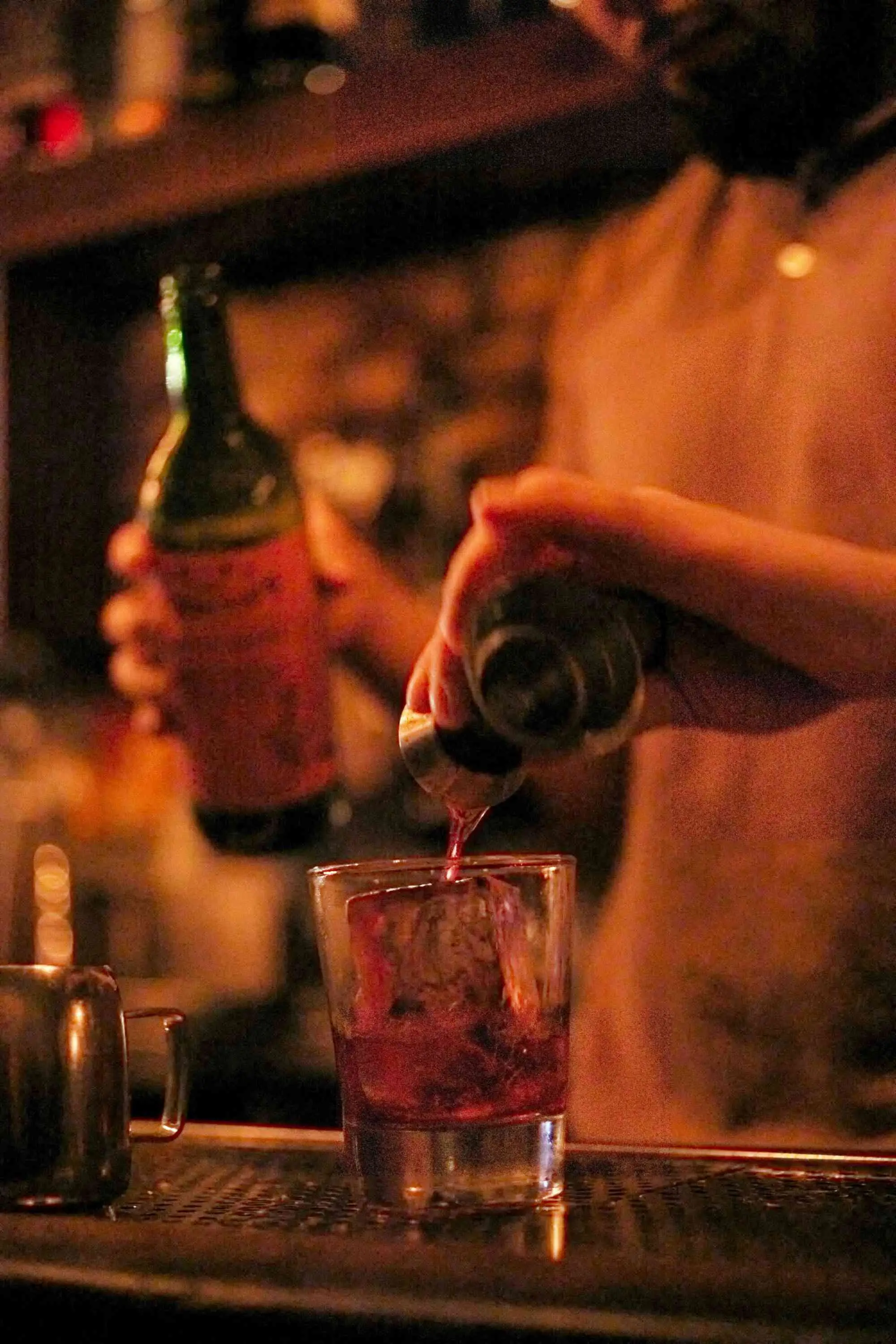 Drink being made in rocks glass with large ice cube at Attaboy