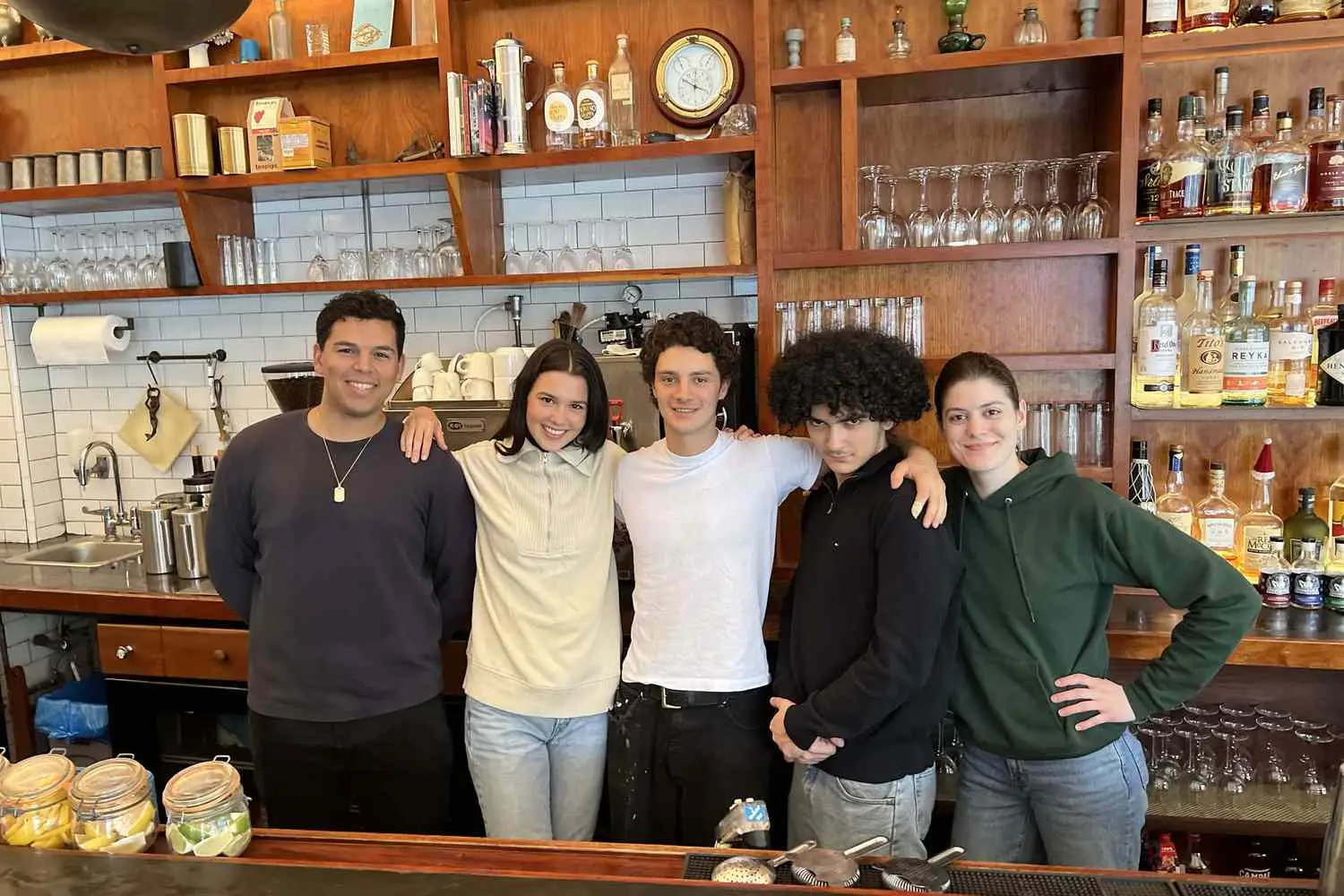 Bar staff of Lighthouse, Brooklyn, arms around each other behind bar