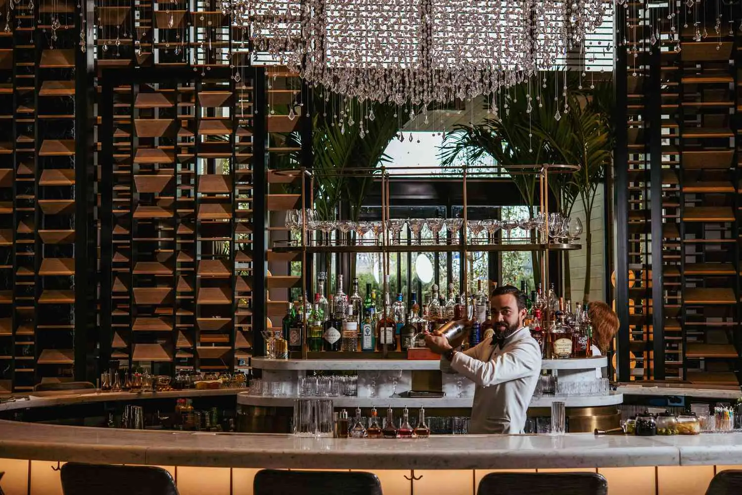Interior of Chandelier Bar with bartender in white suit shaking cocktail