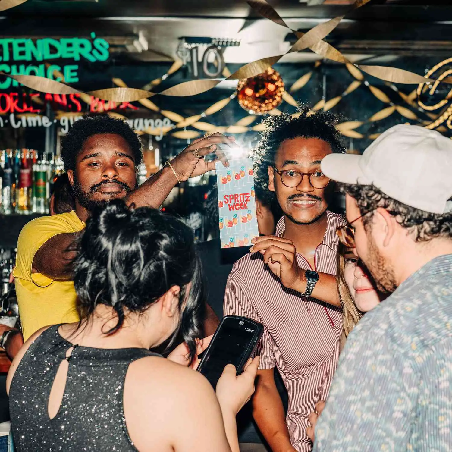 Two people inside Butterscotch Den holding flyer that says Spritz Week