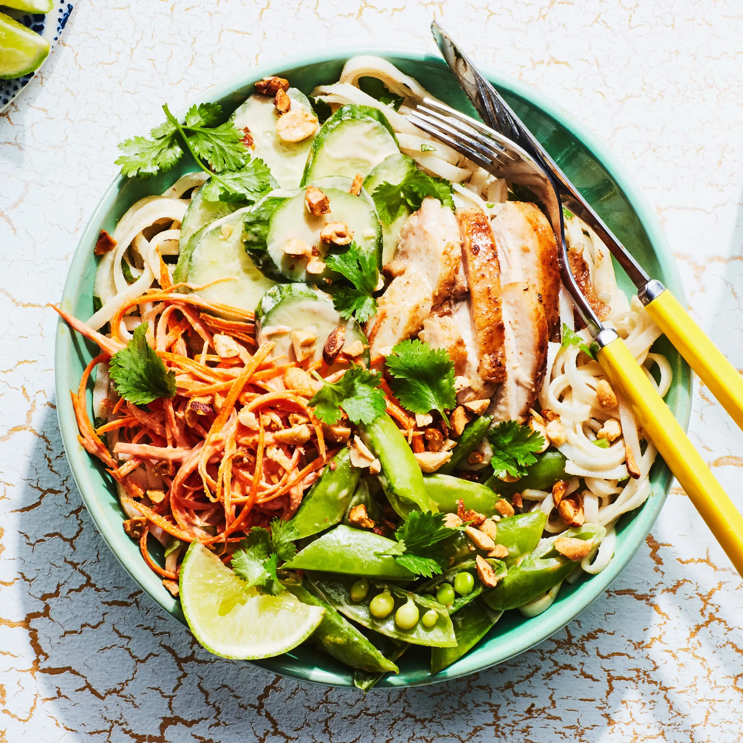 Macarrão de arroz com molho de amendoim, frango e ervilhas