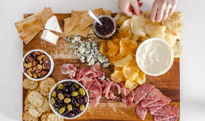Adding the chips and crackers.' title='Easy Snack Board Ideas