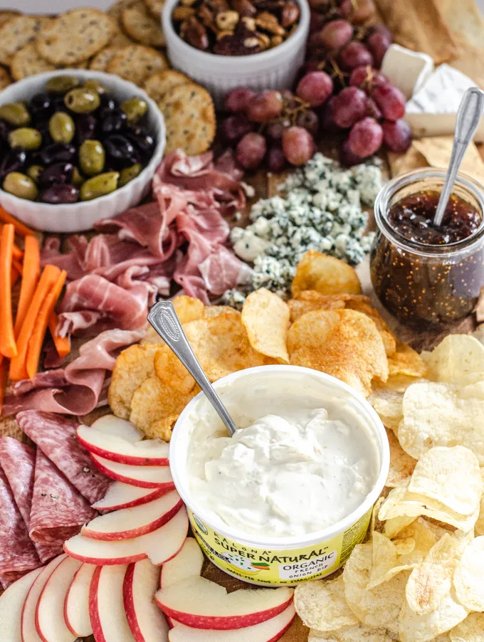 A snack board with nuts crackers grapes brie cheese fig spread olives blue cheese prosciutto carrots chips apples salami and Kalona SuperNatural French onion dip.' title='Easy Snack Board Ideas