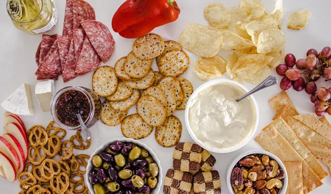 A bunch of different snacks laid out on a white counter.' title='Easy Snack Board Ideas