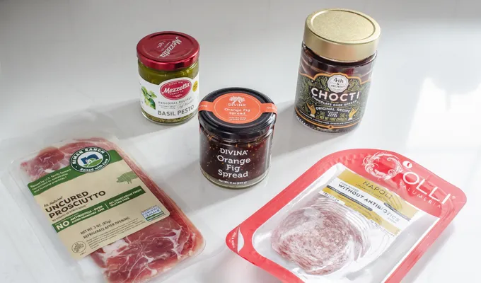 Prosciutto Napoli orange fig spread pesto and chocolate spread all laid out on a counter.' title='Easy Snack Board Ideas