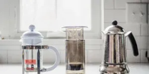 A French press Aeropress and Moka Pot on a white countertop.' title='Matcha Coffee Recipe