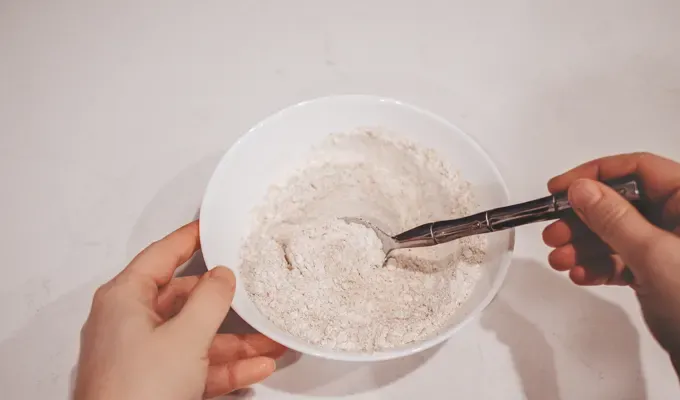 Mixing together a 50/50 blend of whole wheat and all purpose flour to feed my sourdough starter. ' title='How to Make a Sourdough Starter From Scratch