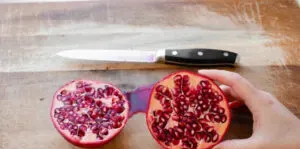Cutting a pomegranate fruit in half.' title='How to Remove Seeds from a Pomegranate