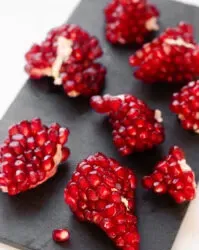 Pomegranate arils on a slate board.' title='How to Remove Seeds from a Pomegranate