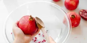 Tapping the back of a pomegranate with a wooden spoon.' title='How to Remove Seeds from a Pomegranate