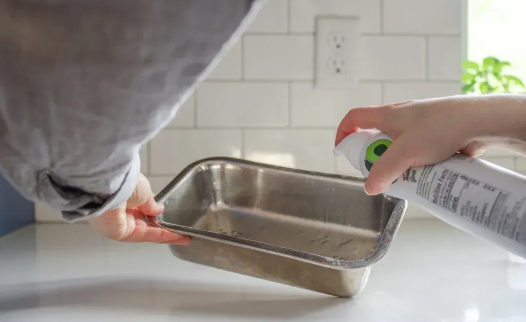 Spraying a pan with cooking oil spray.' title='Parchment Paper Substitute for Baking