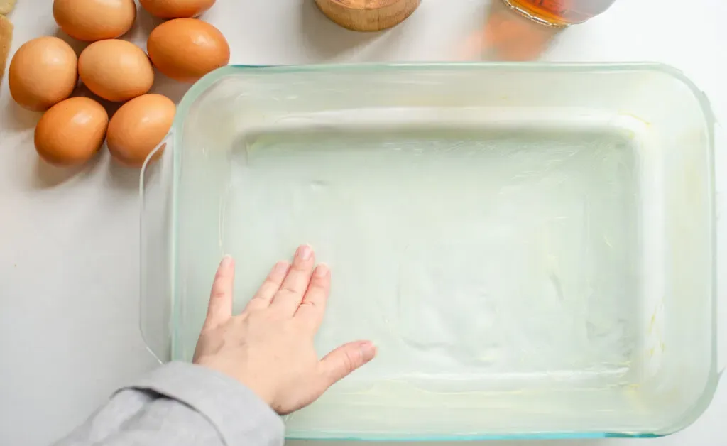 Buttering a 13x9-inch baking dish.' title='Apple French Toast Casserole Recipe