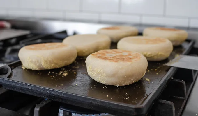 The flipped sourdough English muffins on the griddle.' title='Sourdough English Muffins