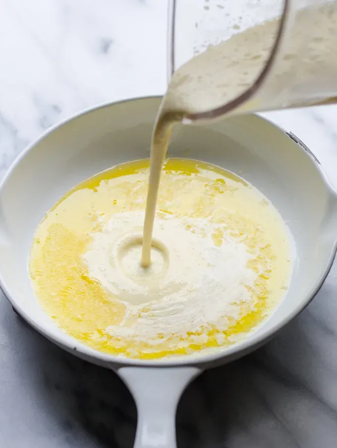 Pouring the batter into the hot buttered pan.' title='Sourdough Dutch Baby/German Pancake
