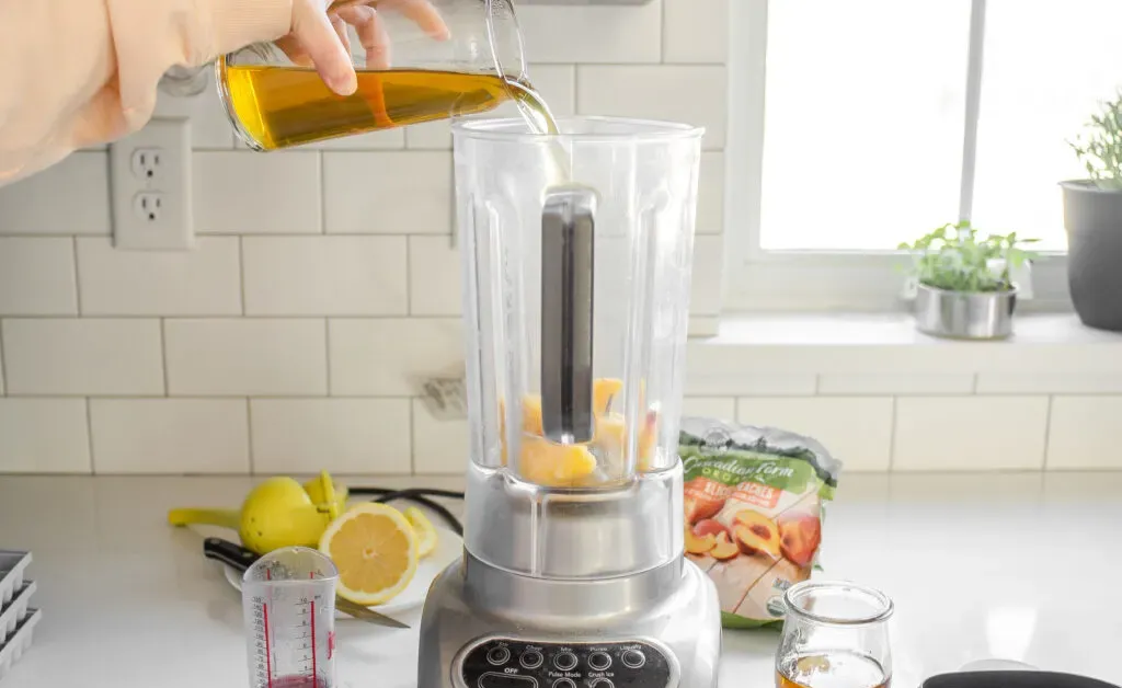Pouring the green tea on top of the peaches in the blender.' title='Starbucks Peach Green Tea Lemonade Recipe