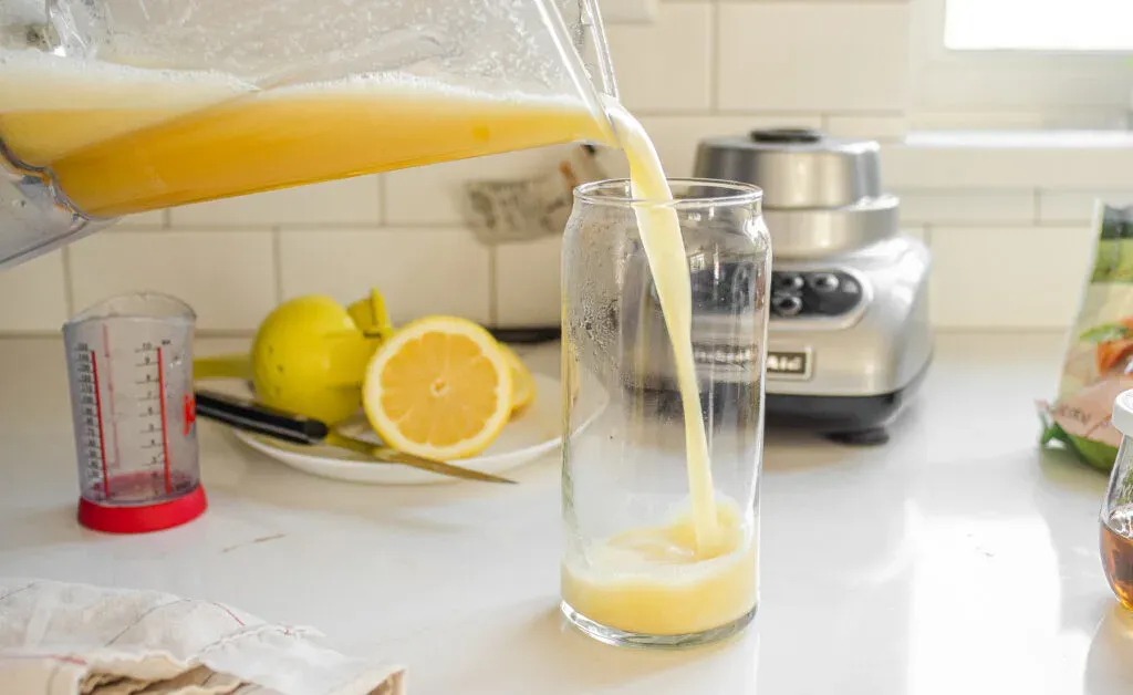 Pouring the homemade Starbucks peach green tea lemonade recipe into a tall glass.' title='Starbucks Peach Green Tea Lemonade Recipe