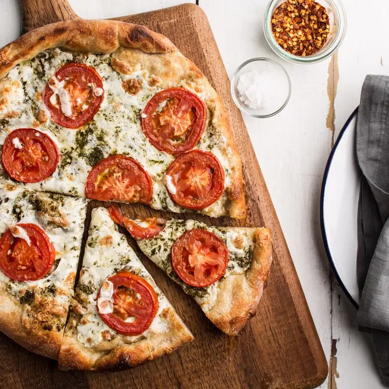 Pizza com pesto, tomate fresco e mussarela