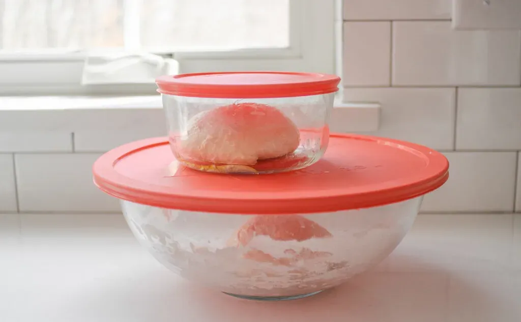 Placing the sourdough pizza dough in greased lidded containers. ' title='Sourdough Pizza Crust Recipe