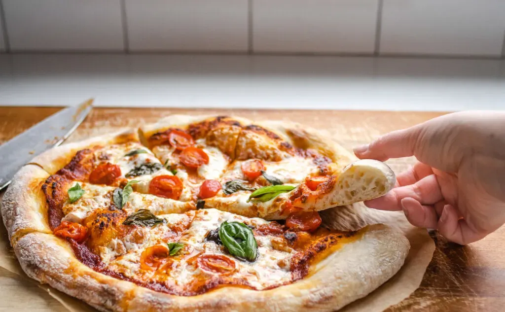 Taking a slice of sourdough pizza.' title='Sourdough Pizza Crust Recipe