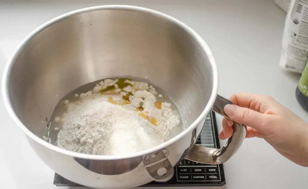 Placing all of the dough ingredients in the bowl of a stand mixer.' title='Sourdough Pizza Crust Recipe