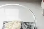 Placing the water and sourdough starter in a large mixing bowl.' title='Sourdough Pizza Crust Recipe