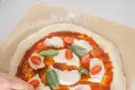 Making a Neapolitan pizza with fresh tomatoes fresh mozzarella cheese and basil.' title='Sourdough Pizza Crust Recipe