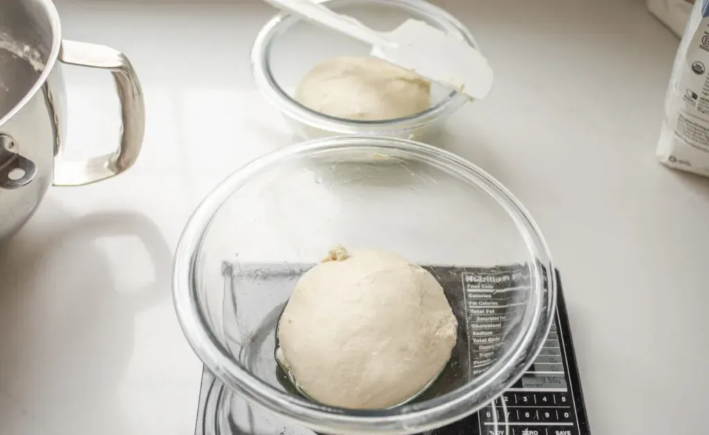 Dividing the sourdough pizza crust into two equal balls.' title='Sourdough Pizza Crust Recipe
