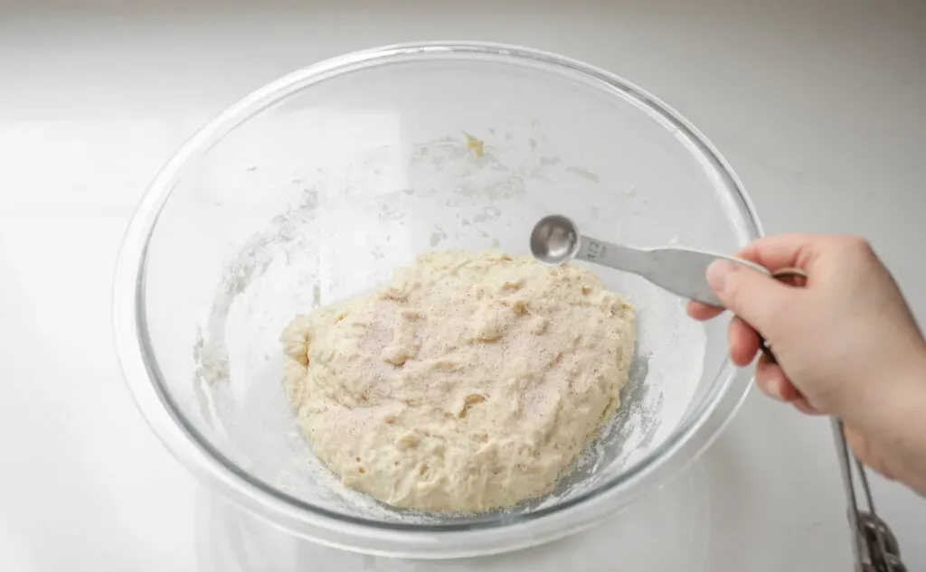 Adding the salt to the sourdough pizza dough.' title='Sourdough Pizza Crust Recipe