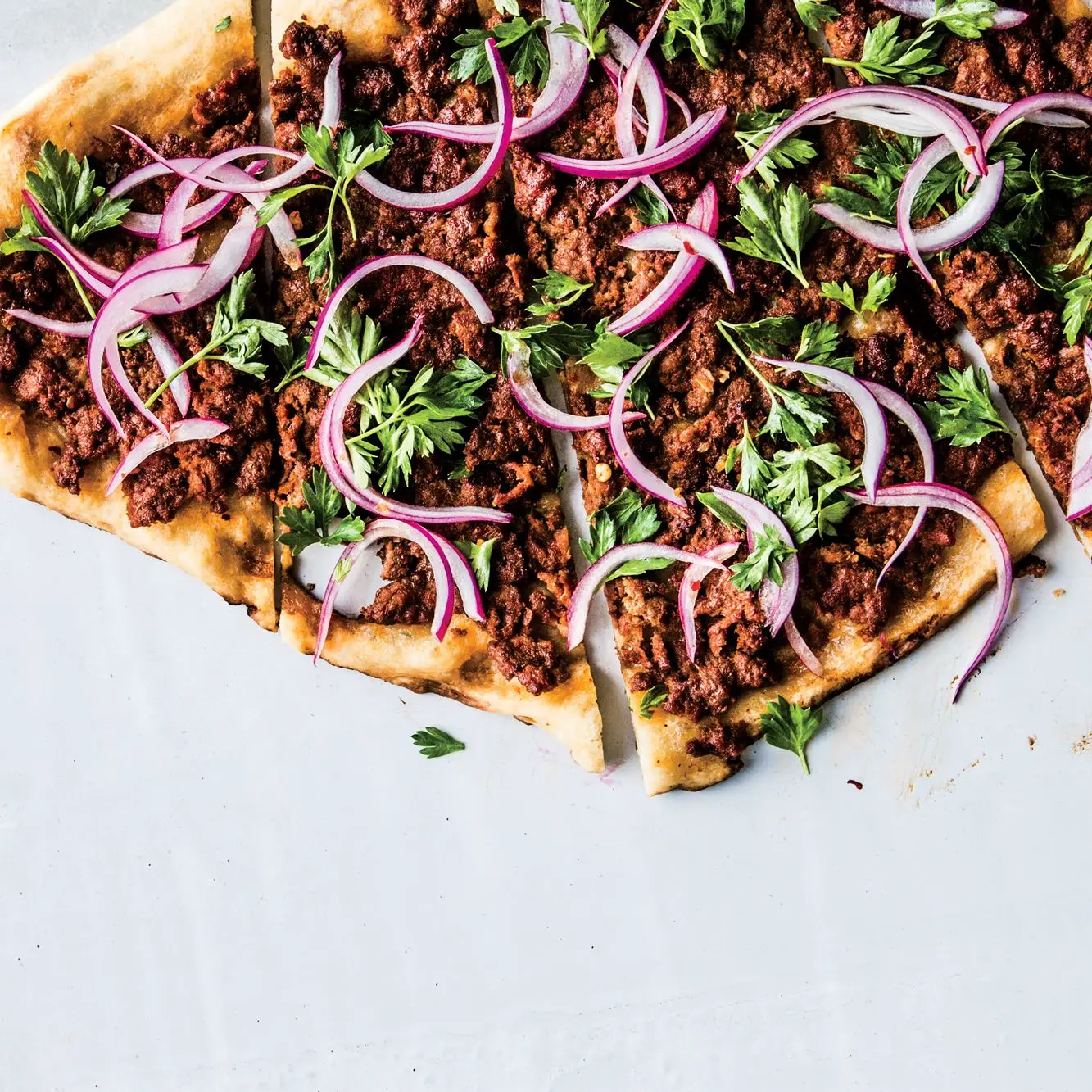 Pizza de cordeiro picante com salada de cebola vermelha de salsa