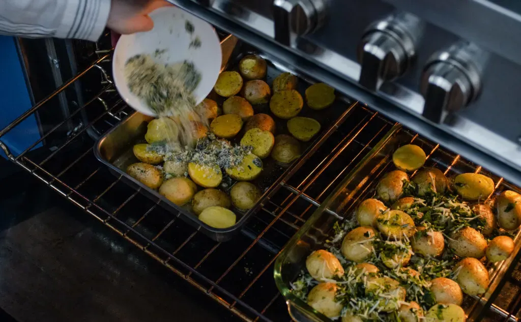 Adding the seasoning blend to the roasting little potatoes in the oven. ' title='Roasted Little Potato Recipe
