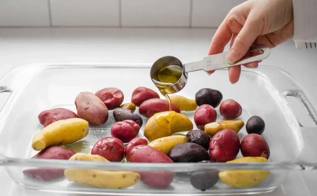 Drizzling the extra virgin olive oil over the mini potatoes. ' title='Roasted Little Potato Recipe