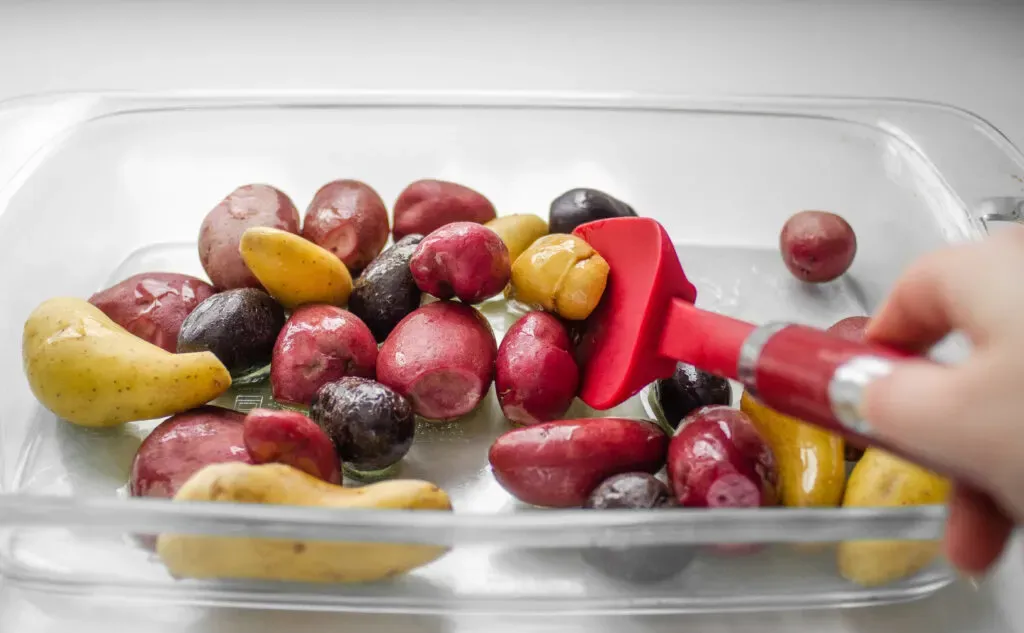 Tossing the baby potatoes with the olive oil in the pan.' title='Roasted Little Potato Recipe