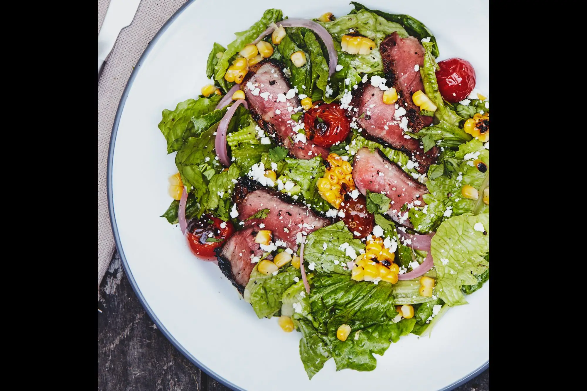 Salada de bife chipotle-coffee com milho e tomate grelhados