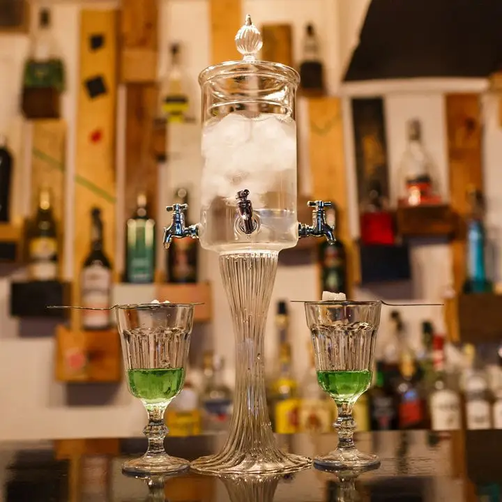 A dual-spouted absinthe fountain with two glasses